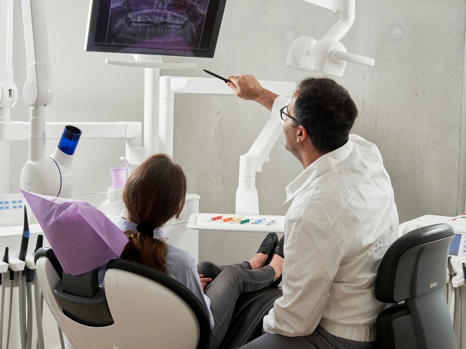 A dentist working chairside with a patient in a bright treatment room