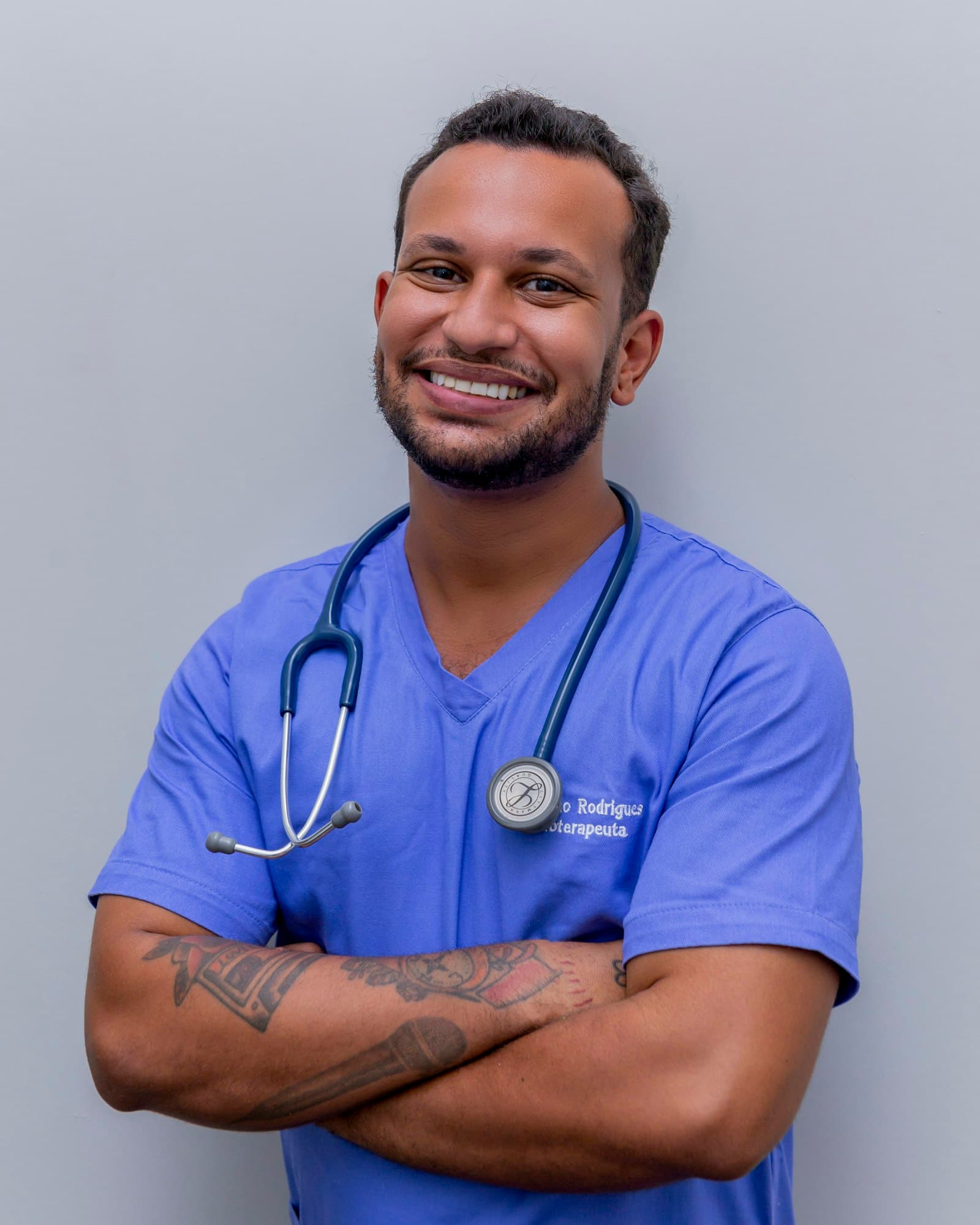 Dr. Marcus Bell in blue scrubs with a stethoscope, smiling warmly