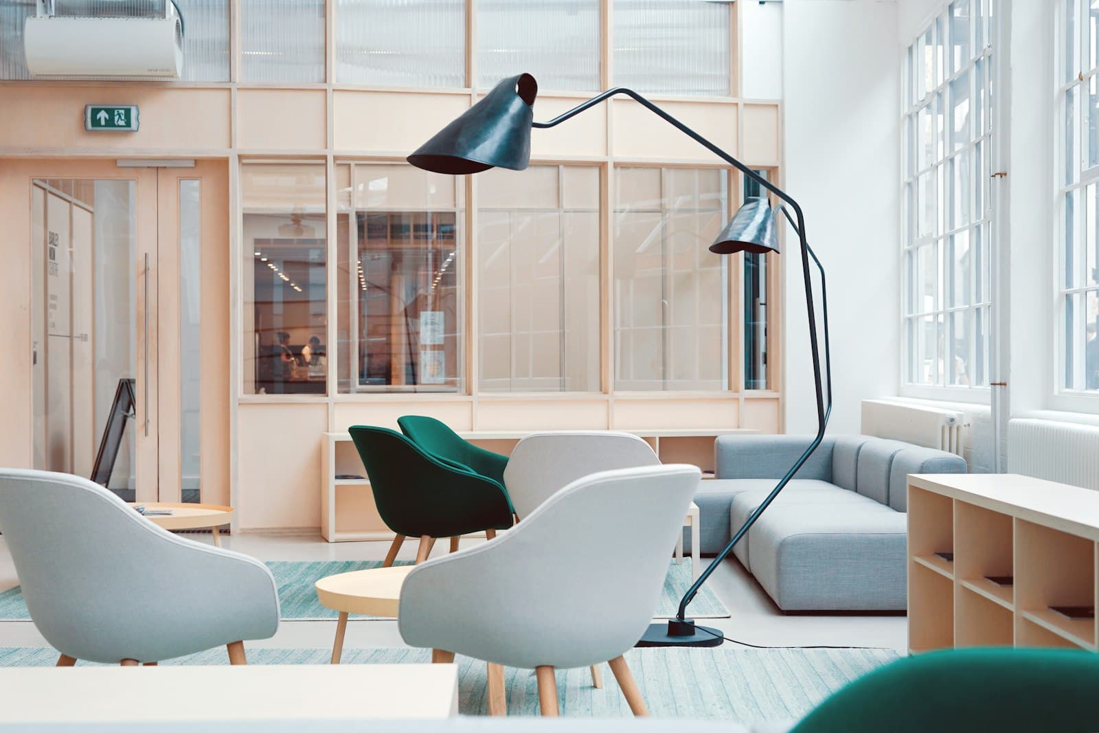The studio lounge with warm wood, soft chairs, and a wall of daylight